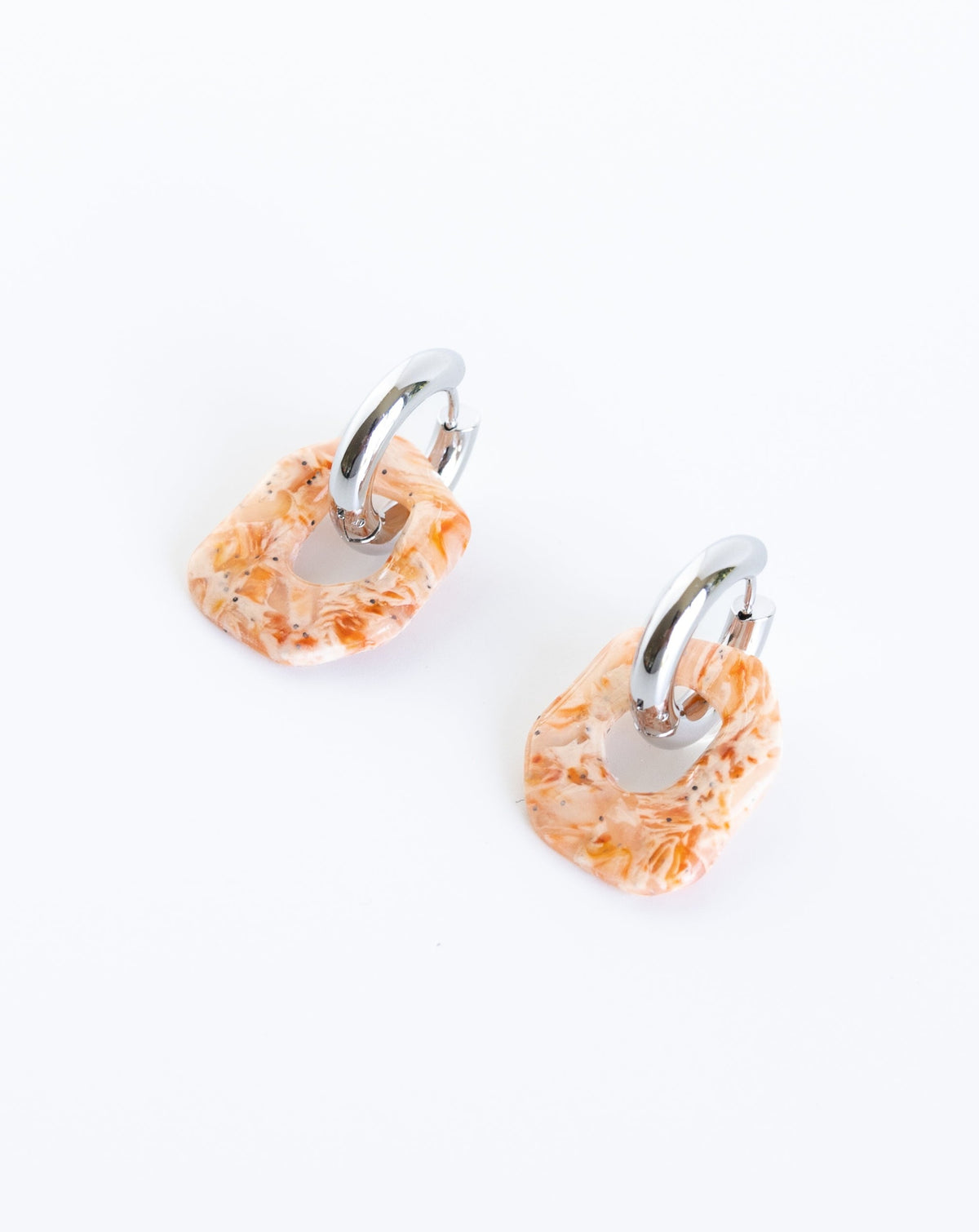 Darien earrings in Marble orange pattern with silver hoops, angled view