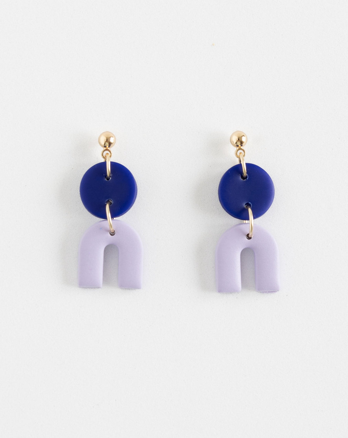 close up of Tiny Arch earrings in two part of Hue Blue and lilac  clay parts with Gold plated Ball studs.
