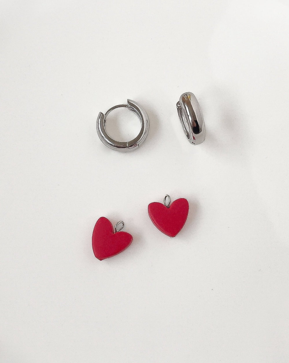 Close up of Charming Heart earrings with silver Hoops and Red Heart charm.
