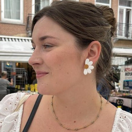Daisy stud earrings on a customer.