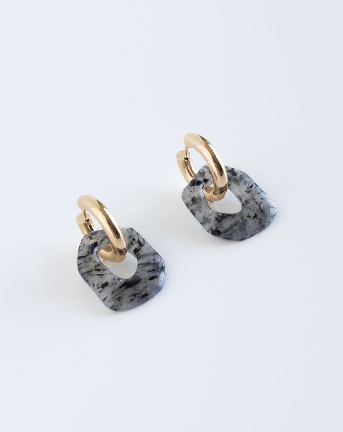 Darien earrings in black Marble pattern with gold hoops, side view