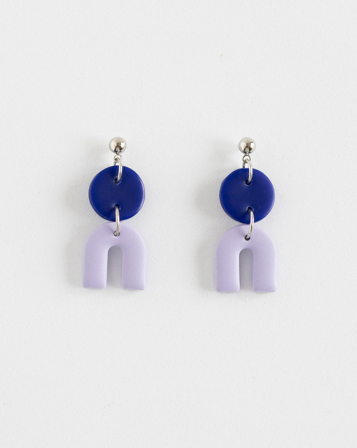 Tiny Arch earrings in two part of Hue Blue and lilac  clay parts with silver Ball studs, front view.