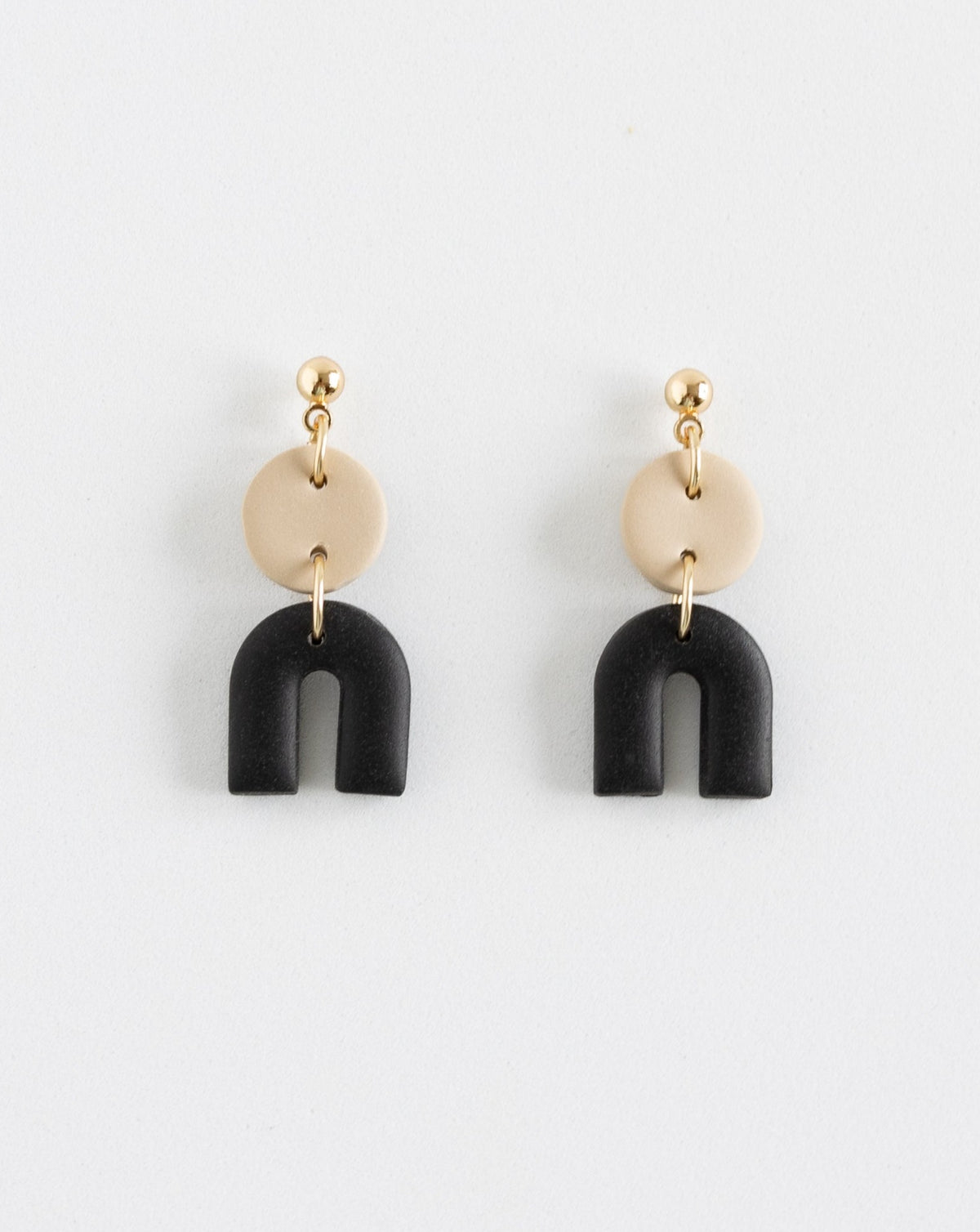 Tiny Arch earrings in two part of Beige and black clay parts with gold plated Ball studs, front view.