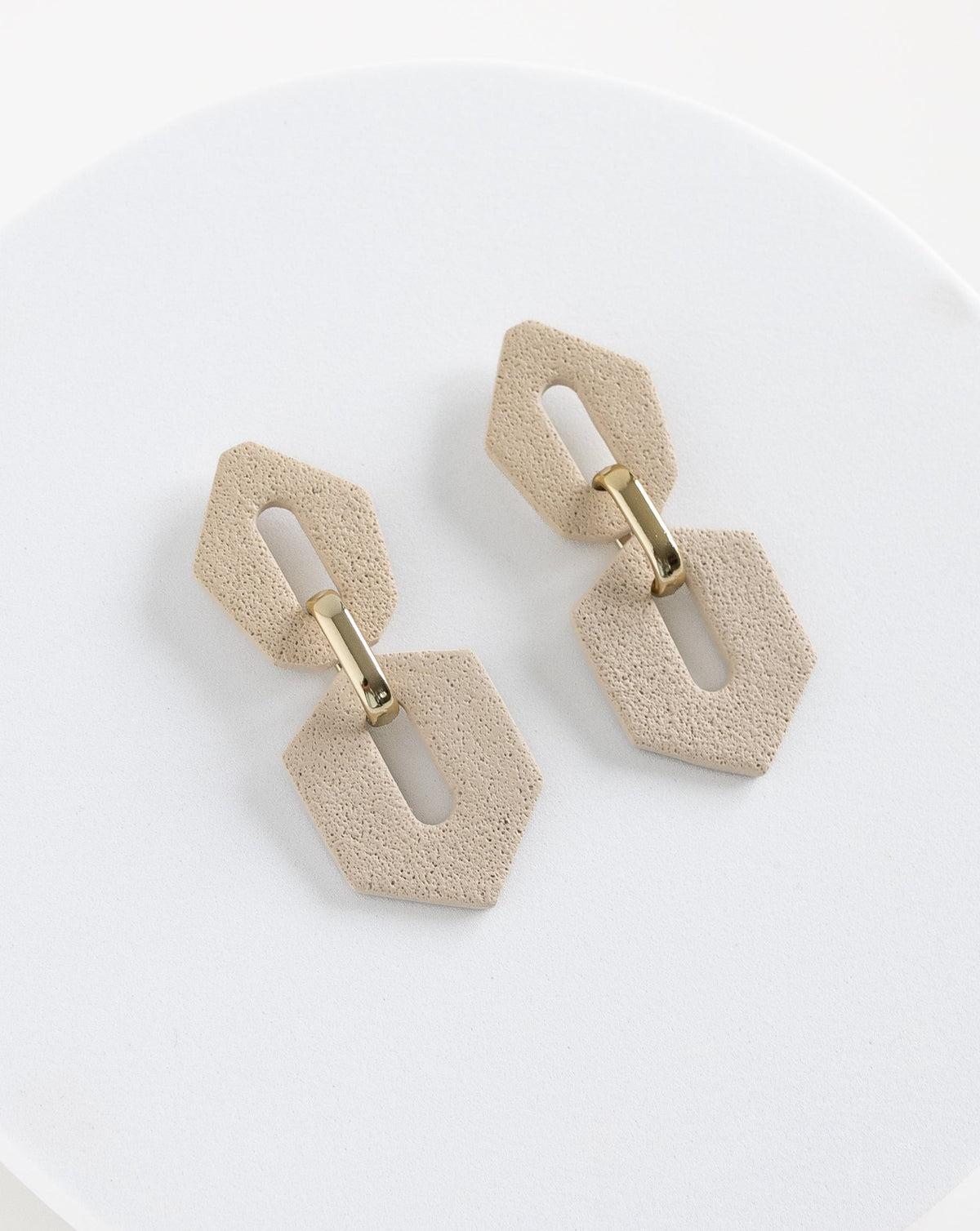Angled view of Shilla earrings in Beige color.