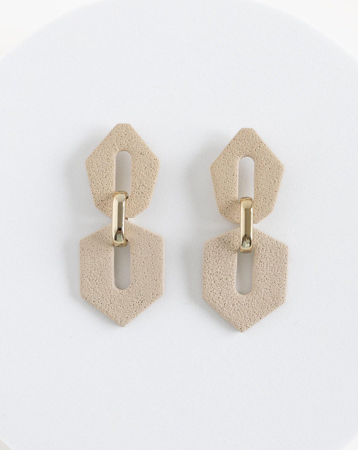 Front view of Shilla earrings in beige color.