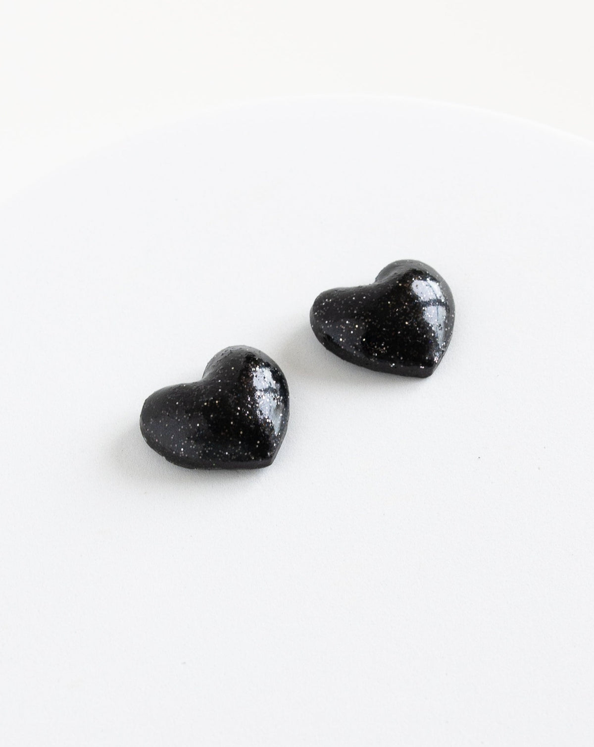 angled view of LYHO heart stud in color black.