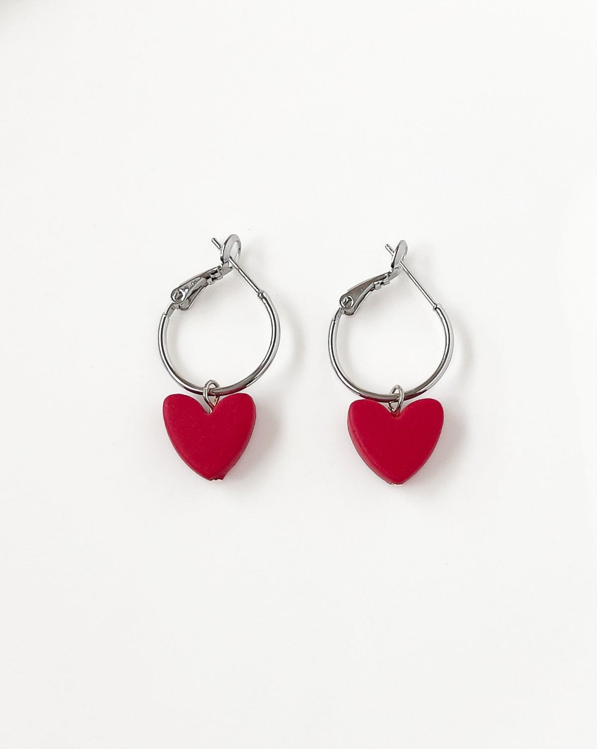 Close up of Charming Heart earrings with silver regular Hoops and Red Heart charm.
