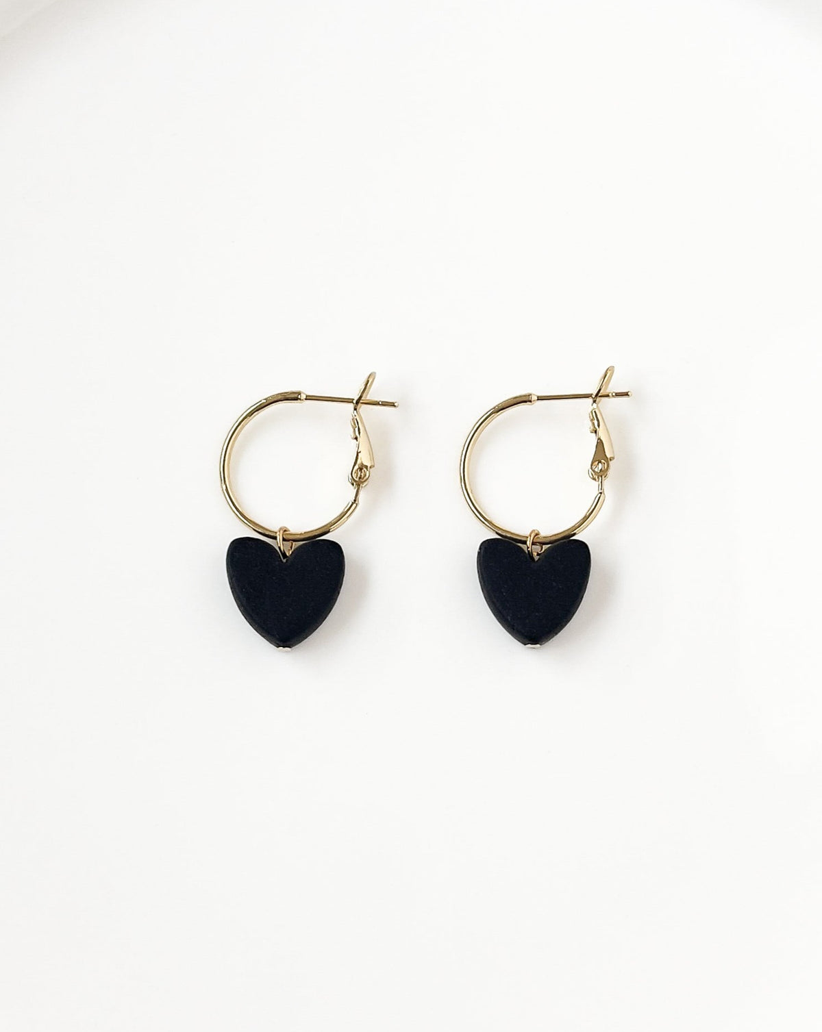 Close up of Charming Heart earrings with Gold regular Hoops and black Heart charm.