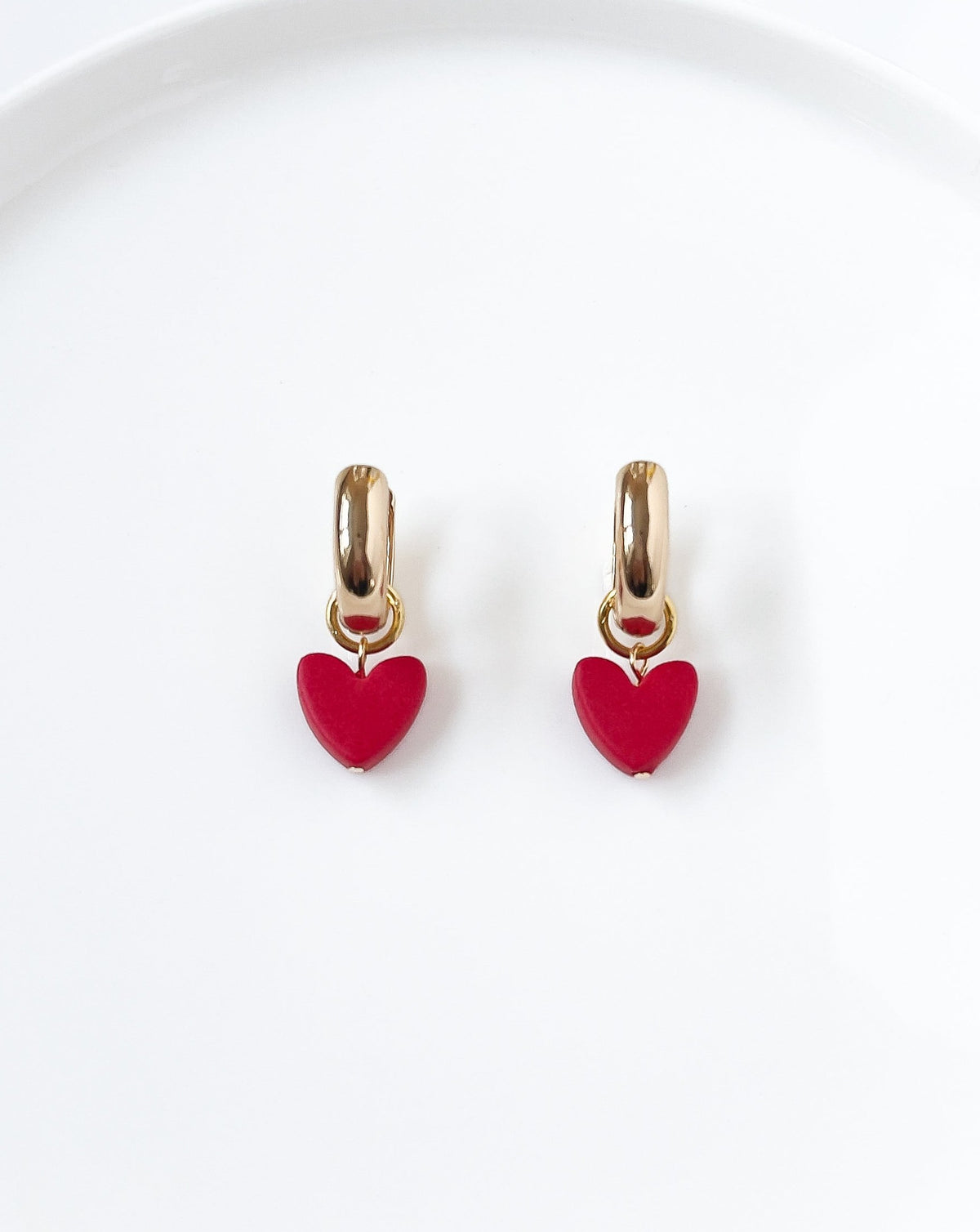 Close up of Charming Heart earrings with Gold Hoops and Red Heart charm.