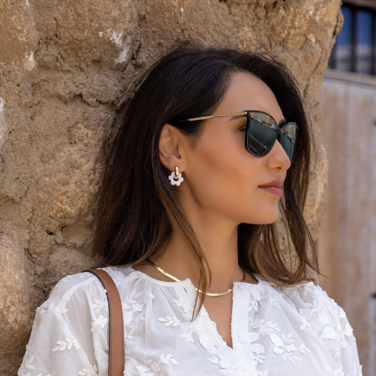 white Goli hoop earrings on model.