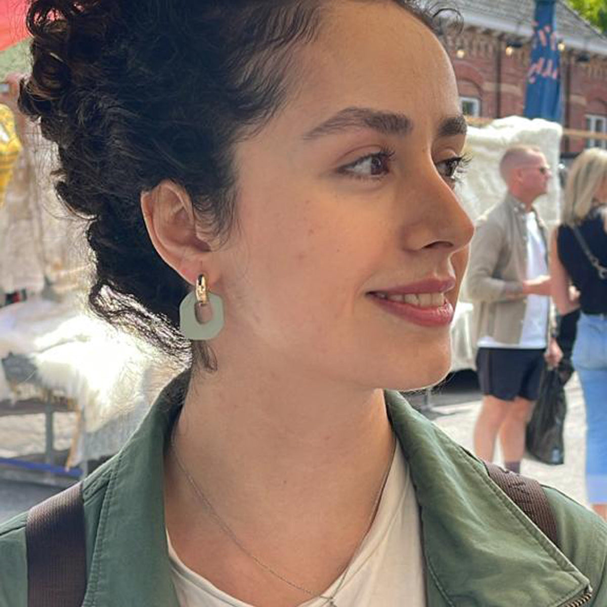 Darien earrings in Sage color with gold hoops, on model
